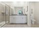 Bright bathroom featuring a double sink vanity, granite countertop, a glass shower, and tile flooring at 1240 Blue Daze Ln, Eustis, FL 32726