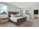 Beautiful bedroom with a padded headboard, carpeted flooring, natural light, and calming decor at 1240 Blue Daze Ln, Eustis, FL 32726