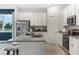 Well-lit kitchen with granite countertops, stainless steel appliances, white cabinets, and a view to the outdoors at 1240 Blue Daze Ln, Eustis, FL 32726