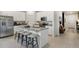 Modern kitchen featuring white cabinets, granite countertops, stainless steel appliances, and an island with stool seating at 1240 Blue Daze Ln, Eustis, FL 32726