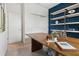 Modern office boasts a large wood desk, a contemporary bookshelf, and neutral carpeting at 1240 Blue Daze Ln, Eustis, FL 32726