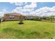 A large, grassy backyard is surrounded by a black fence and offers plenty of room for recreation and relaxation at 125 Silver Maple Rd, Groveland, FL 34736