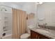 Bathroom with granite countertop, bath tub and shower with light-colored curtain at 125 Silver Maple Rd, Groveland, FL 34736