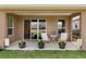 This covered patio features comfortable seating and pretty plantings, perfect for outdoor entertaining with access to the yard at 125 Silver Maple Rd, Groveland, FL 34736