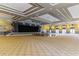 Expansive event hall featuring a stage with black curtains, rows of chairs, and elegant lighting at 125 Silver Maple Rd, Groveland, FL 34736