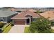Charming single Gathering home boasts well-manicured landscaping and a two-car garage, with stone accents on the facade at 125 Silver Maple Rd, Groveland, FL 34736