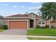 Charming single-story home featuring a stone facade, two-car garage, and well-maintained landscaping at 125 Silver Maple Rd, Groveland, FL 34736