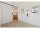 Hallway featuring tile floors, a barn door, and mirrors on the wall at 125 Silver Maple Rd, Groveland, FL 34736