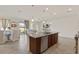 Kitchen island with seating overlooks dining and living areas in this open floor plan with neutral color palette at 125 Silver Maple Rd, Groveland, FL 34736