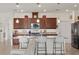 Kitchen features large center island with seating, granite counters, pendant lights and view to living area at 125 Silver Maple Rd, Groveland, FL 34736