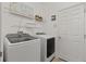Laundry room featuring side-by-side washer and dryer, wire shelving, and white walls at 125 Silver Maple Rd, Groveland, FL 34736