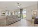 Bright living room with sliding glass doors opening to backyard and patio, neutral color palette and tile floors at 125 Silver Maple Rd, Groveland, FL 34736