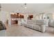 Open-concept living room showcasing seamless flow to kitchen and dining with neutral color palette and tile floors at 125 Silver Maple Rd, Groveland, FL 34736