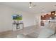Spacious living room with kitchen view, with TV and barn door media console at 125 Silver Maple Rd, Groveland, FL 34736