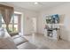 Bright living room with sliding glass doors opening to backyard and patio, with TV and barn door media console at 125 Silver Maple Rd, Groveland, FL 34736