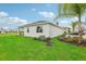 Well-manicured backyard with lush green grass, mature landscaping, and a white exterior at 1251 Blue Daze Ln, Eustis, FL 32726