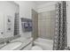Bathroom featuring a shower over tub with gray tile and a gray patterned shower curtain at 1251 Blue Daze Ln, Eustis, FL 32726