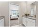 Bright bathroom features granite counters, a white vanity, and a view into an airy bedroom with large windows at 1252 Blue Daze Ln, Eustis, FL 32726