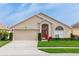 Charming single-story home with a well-manicured lawn, arched windows and a two car garage at 128 Brushcreek Dr, Sanford, FL 32771