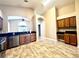 Well-lit kitchen boasts stainless appliances, wood cabinets, tile floor and view to living room at 128 Brushcreek Dr, Sanford, FL 32771