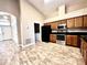 Open kitchen featuring stainless steel appliances, wood cabinets, tile floor, and attached laundry closet at 128 Brushcreek Dr, Sanford, FL 32771