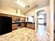 Open kitchen with stainless steel appliances, wood cabinets, granite counters and tile floors at 128 Brushcreek Dr, Sanford, FL 32771