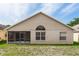 Rear exterior of the home featuring a screened-in patio and views of the large backyard at 128 Brushcreek Dr, Sanford, FL 32771