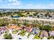 Aerial view of a single-Gathering home with a well-maintained lawn and a golf course in the distance at 140 Elgin Blvd, Davenport, FL 33897