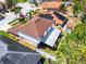 Aerial view of a charming home featuring a well-manicured lawn, enclosed patio, and solar panels on a neighboring roof at 140 Elgin Blvd, Davenport, FL 33897