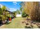 Large, private backyard featuring lush greenery, a screened-in patio, and mature trees, offering a serene outdoor retreat at 140 Elgin Blvd, Davenport, FL 33897