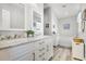 Bright bathroom featuring double vanity, marble counters, white cabinets, and decorative wall art at 140 Elgin Blvd, Davenport, FL 33897