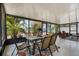 Sunroom with ample seating, a glass table, outdoor rug, and scenic views of lush greenery for tranquility at 140 Elgin Blvd, Davenport, FL 33897