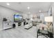 Bright living room with modern decor, wood-look tile floors, and a large TV entertainment center at 140 Elgin Blvd, Davenport, FL 33897
