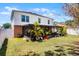 Exterior view of a well-maintained home, showcasing a spacious screened-in patio and landscaped backyard with mature trees at 140 Elgin Blvd, Davenport, FL 33897