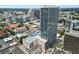 Aerial view of a modern condo building with rooftop amenities including a pool and recreation areas, offering city views at 150 E Robinson St # 717, Orlando, FL 32801