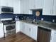A modern kitchen with stainless steel appliances, granite countertops, and blue backsplash at 150 E Robinson St # 717, Orlando, FL 32801