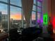 Comfortable living room with floor to ceiling windows showing colorful sunset city views at 150 E Robinson St # 717, Orlando, FL 32801