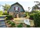 Rustic barn-style structure with a decorative water wheel, complemented by a small pond and lush landscaping at 15305 Shady Ln, Tavares, FL 32778
