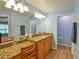 Bright bathroom featuring double vanity with granite countertops and wood-look floors, exuding elegance at 15305 Shady Ln, Tavares, FL 32778