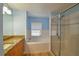 Well-lit bathroom with separate glass-enclosed shower and tub, enhanced by granite vanity and wood-look floors at 15305 Shady Ln, Tavares, FL 32778