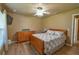 Bedroom with wooden bed frame, side table and a window with blinds at 15305 Shady Ln, Tavares, FL 32778
