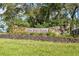 Stone entrance sign to Old Mill Run neighborhood, surrounded by mature trees and landscaping at 15305 Shady Ln, Tavares, FL 32778
