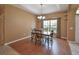 Inviting dining room featuring wood floors, modern light fixture, and a view of the landscaped backyard at 15305 Shady Ln, Tavares, FL 32778
