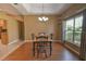 Dining room featuring a tray ceiling, chandelier, wood floors, and large window at 15305 Shady Ln, Tavares, FL 32778