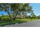 Gated home showcasing a long driveway, mature trees, and well-maintained landscaping at 15305 Shady Ln, Tavares, FL 32778