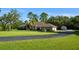 Exterior of home with mature landscaping, palm tree, and long private driveway at 15305 Shady Ln, Tavares, FL 32778