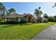 Exterior of home with a lush front lawn, large windows, and mature landscaping at 15305 Shady Ln, Tavares, FL 32778