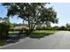View of gated entry to a home with mature trees, long driveway and well-manicured lawn at 15305 Shady Ln, Tavares, FL 32778