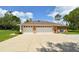 Spacious three-car garage with white doors and ample parking space on a sunny day at 15305 Shady Ln, Tavares, FL 32778