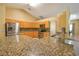 Beautiful kitchen with stainless steel appliances, wood cabinets, and granite countertops at 15305 Shady Ln, Tavares, FL 32778